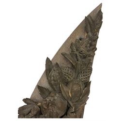 Early 20th century figural torchère, modelled as a standing putto supporting a circular top with tasselled drapery effect, raised on a circular base with foliate moulding; together with a 19th century large carved wood fragment, triangular form with high relief fruit, foliage and shell motif (H23cm, W129cm)