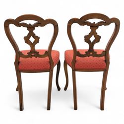 Set of four Victorian walnut balloon back chairs, with a carved and pierced back splat with foliate scrolls, serpentine seat upholstered in a diamond pattern fabric, raised on cabriole legs 