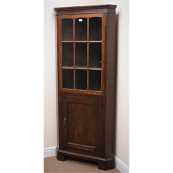  Early 20th century oak floor standing corner cabinet, projecting cornice, single glazed doors enclosing two shelves above single cupboard door, shaped plinth base, W77cm, H182cm, D40cm  