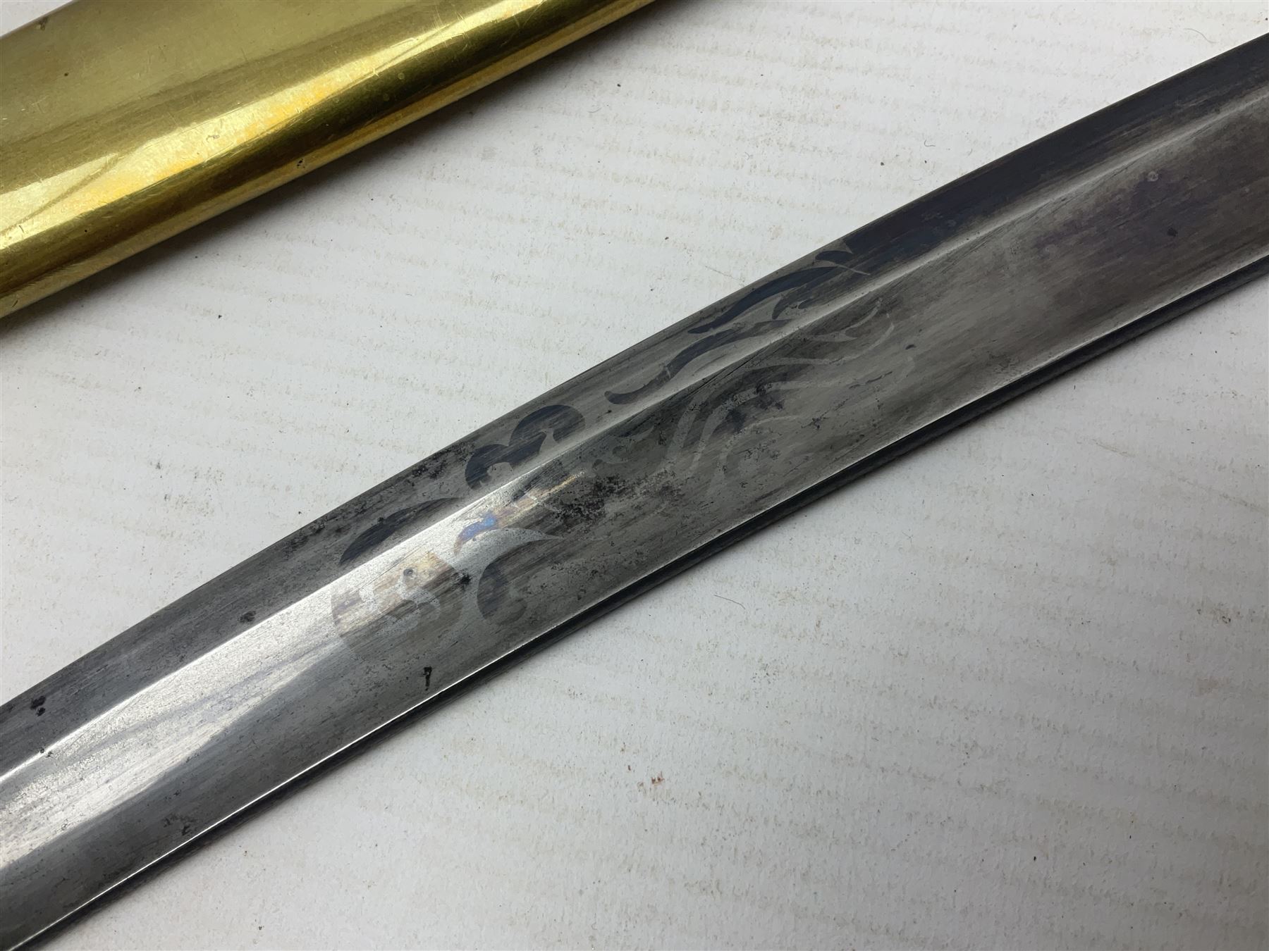 German Saxon 1st Empire Light Cavalry officer's sword c1820s, the 79cm clipped curving blade engraved with the crest of Hanover and various battle trophies with traces of blueing and gilding, brass hilt with knucklebow, foliate square langets, ornate downswept quillon, wire-bound fish skin grip with lion's head pommel; in brass scabbard with two suspension rings L95cm overall