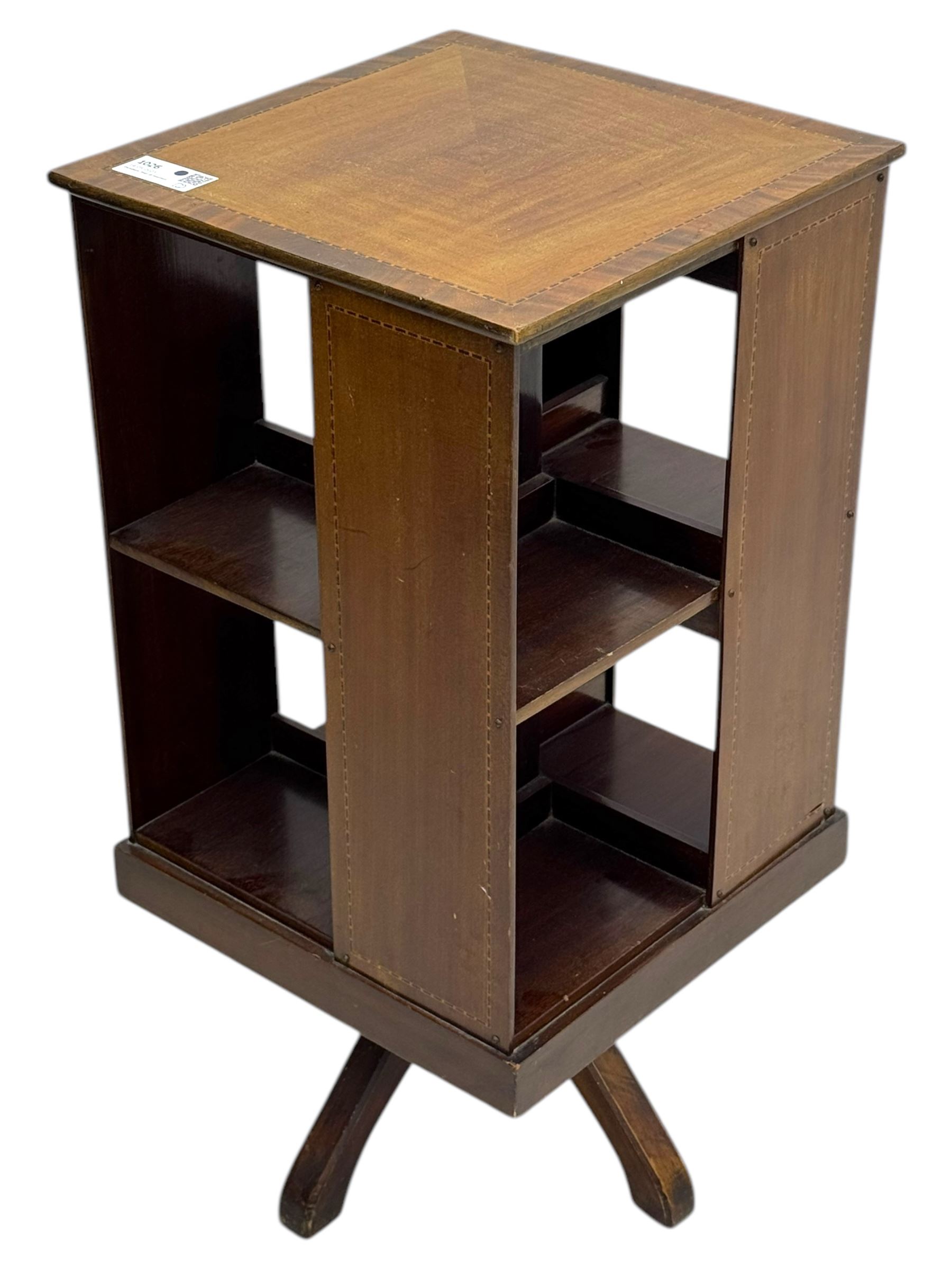 Edwardian inlaid mahogany revolving bookcase, square top, two tier open book compartments, on a cruciform base with splayed feet 