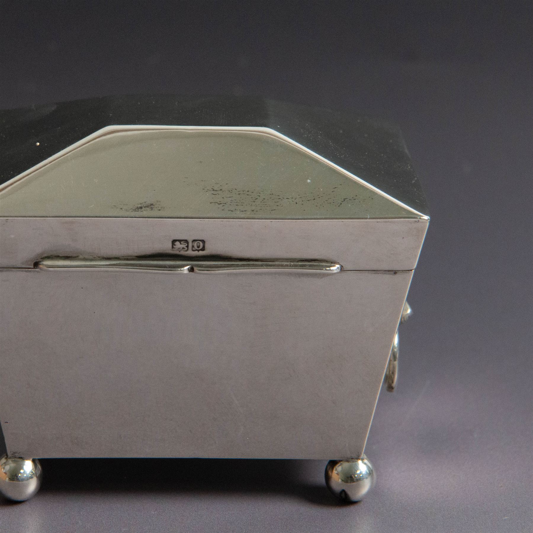 Early 20th century silver tea caddy, of sarcophagus form with twin lion mask mounted loop handles, upon four bun feet, hallmarked William Hutton & Sons Ltd, Birmingham 1913, H8cm, W9cm
