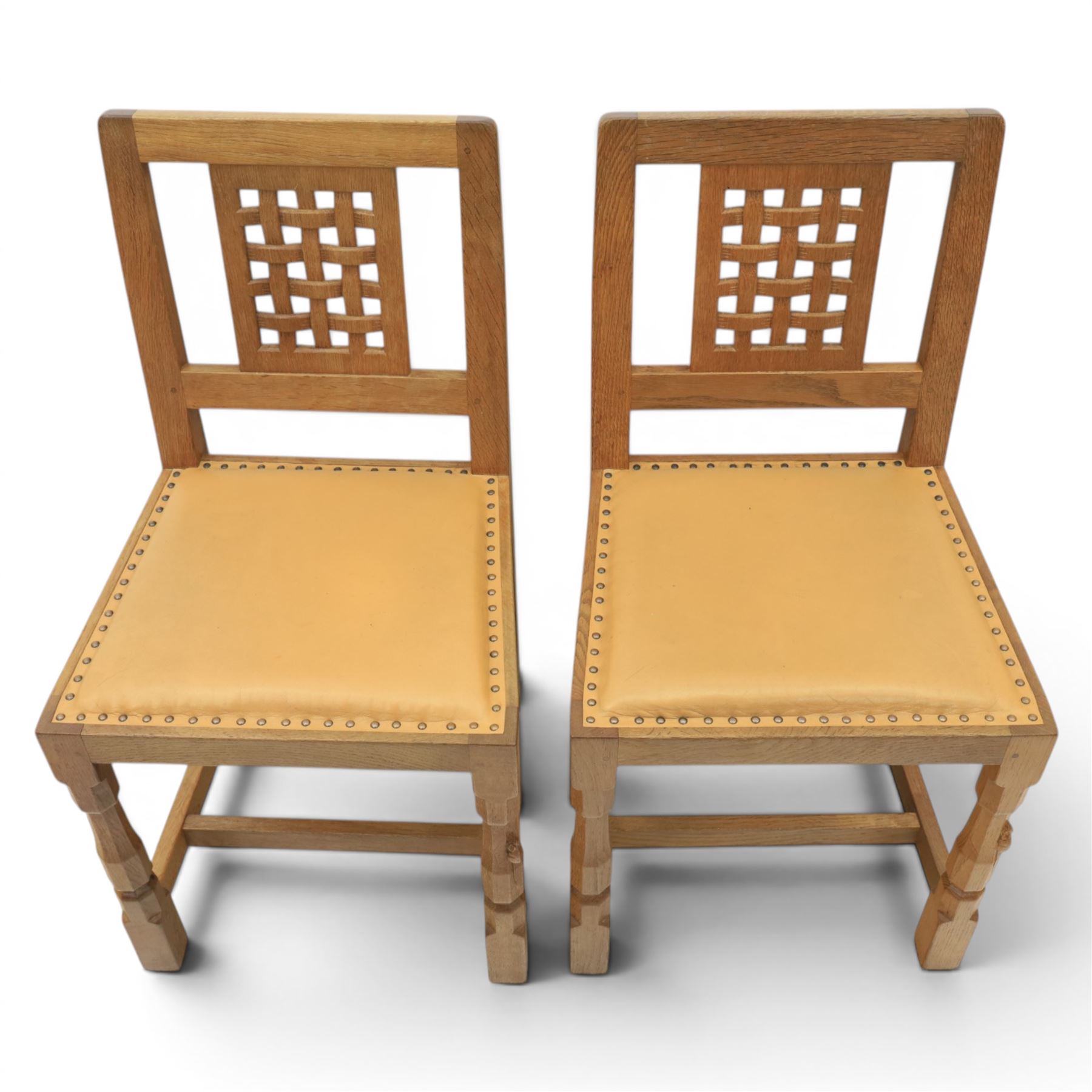 Mouseman - set of four oak lattice back chairs with tan seat with brass studded trim, with carved mouse signature, by the workshop of Robert Thompson of Kilburn