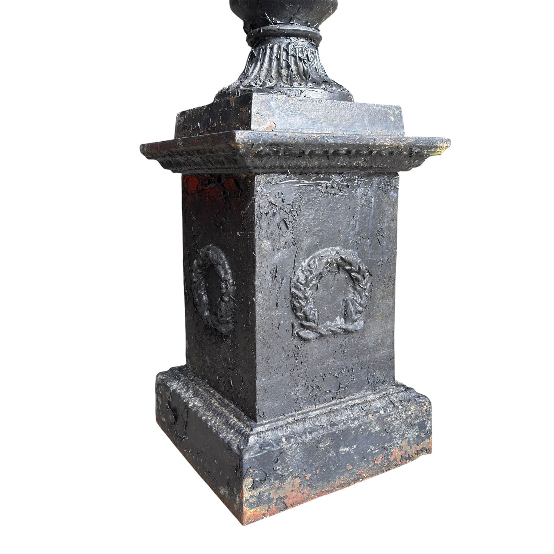 Pair of Victorian cast iron campana form garden urns, the gadrooned flared edge over a scrolling acanthus relief body, with twin male mask handles to each side, over a lobed underbelly with fluted socle, the rectangular pedestals with relief floral garlands and stepped base, in rustic black-painted finish, planted