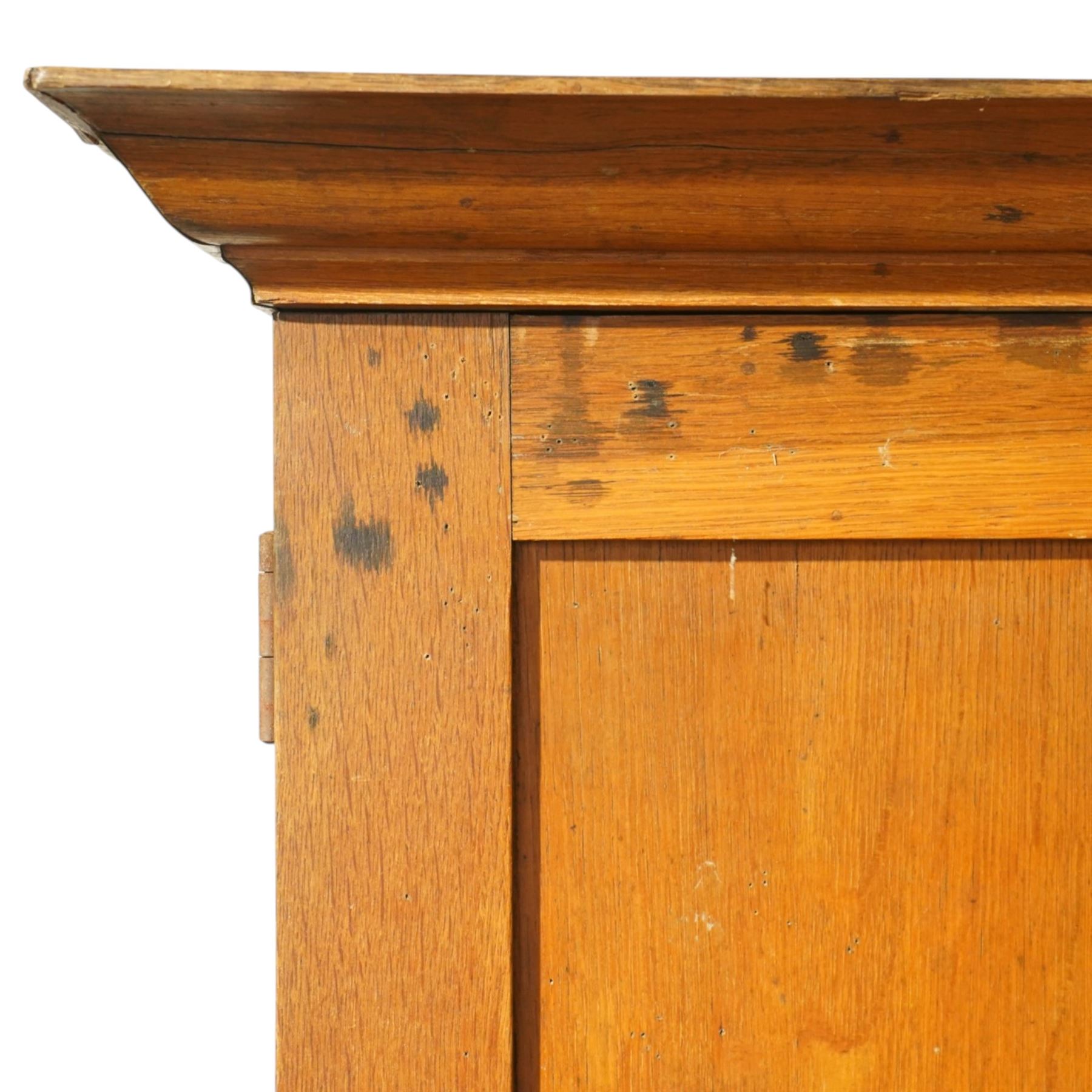 Early 20th century Arts and Crafts oak housekeeper’s cupboard, moulded cornice above pair of panelled doors enclosing a shelved interior, on plinth base