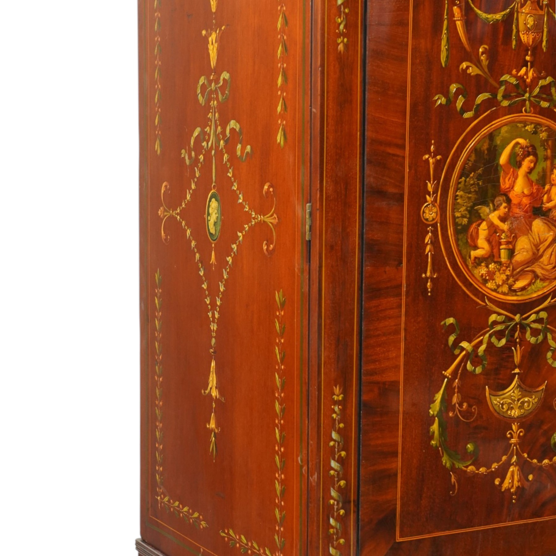 19th century French Louis XVI design mahogany and polychrome painted gentleman's press wardrobe - projecting cavetto cornice with urn and bellflower painted frieze, the twin doors with classical figural medallions surmounted by urns and festoon decoration with scrolling acanthus leaves, enclosing five sliding trays, the base fitted with two short over three long cock-beaded drawers, the facias painted with interlocking swags and garlands of bouquets with recumbent lion brass handle-plates, lower reeded edge on turned feet