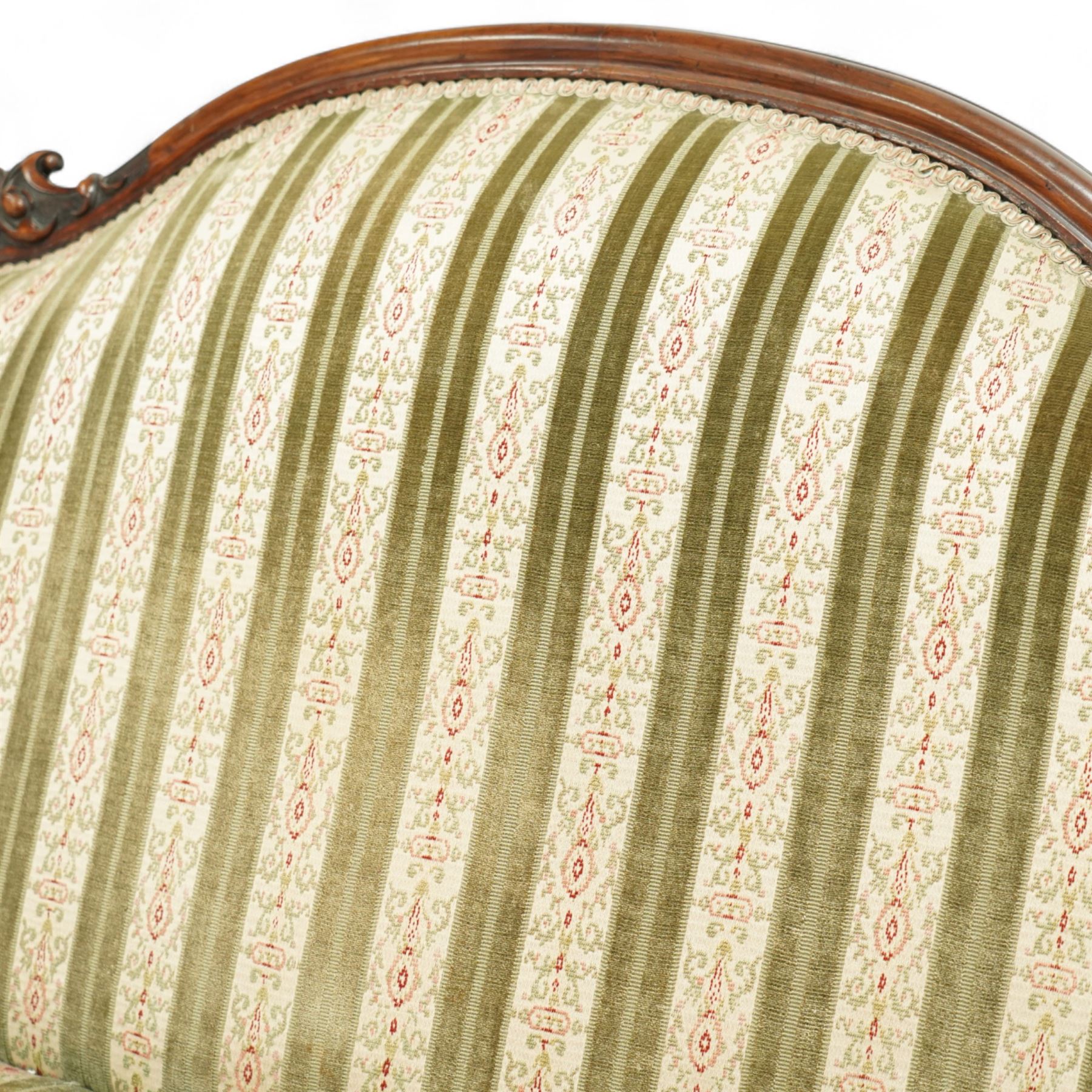 Victorian walnut framed salon sofa, the shaped back and scroll arms with carved floral detail, upholstered in green and cream striped fabric, raised on scrolled cabriole legs 