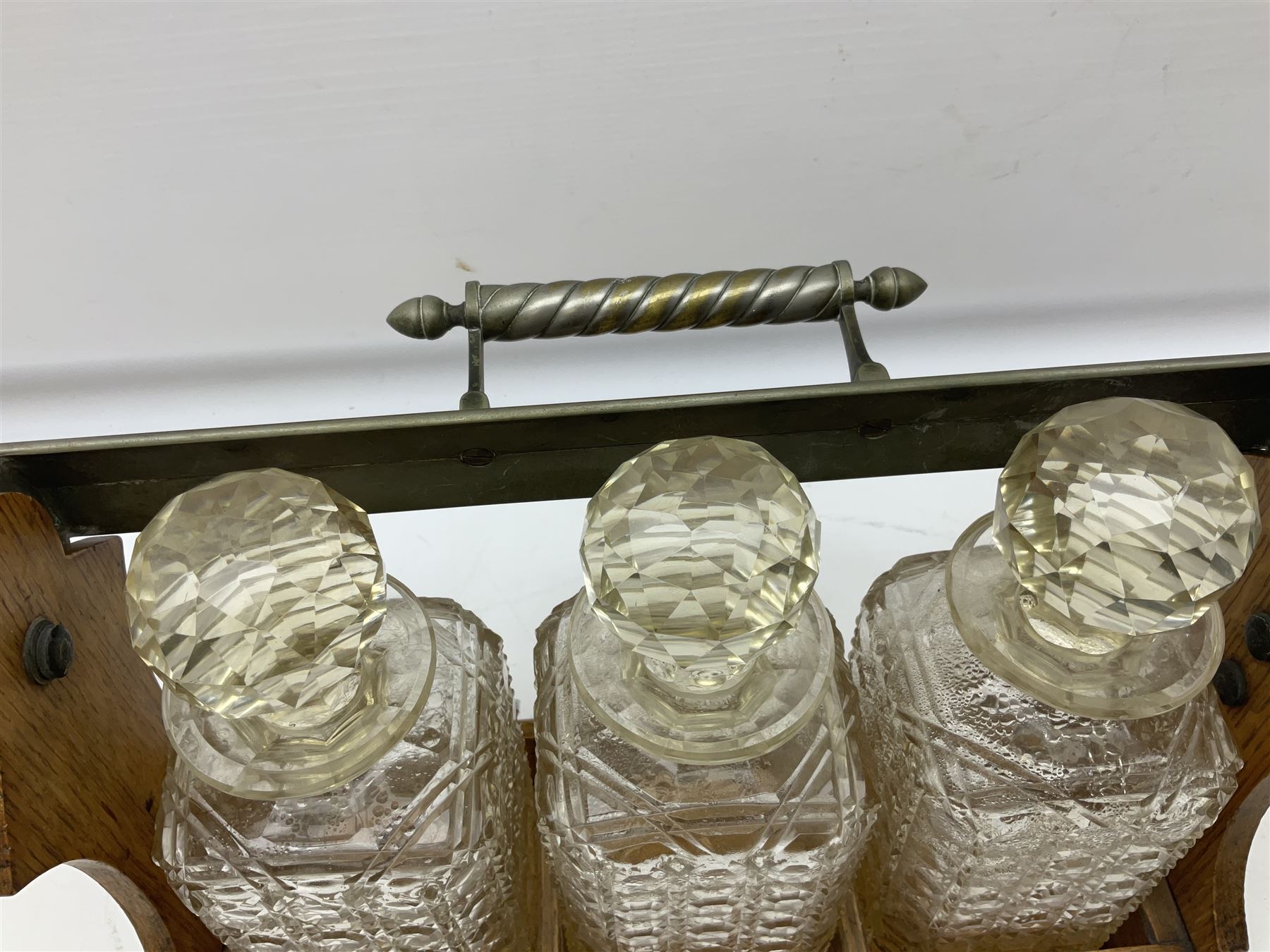 Betjemann patent silver plate mounted oak tantalus, containing three square sided cut glass decanters, complete with key, H30cm