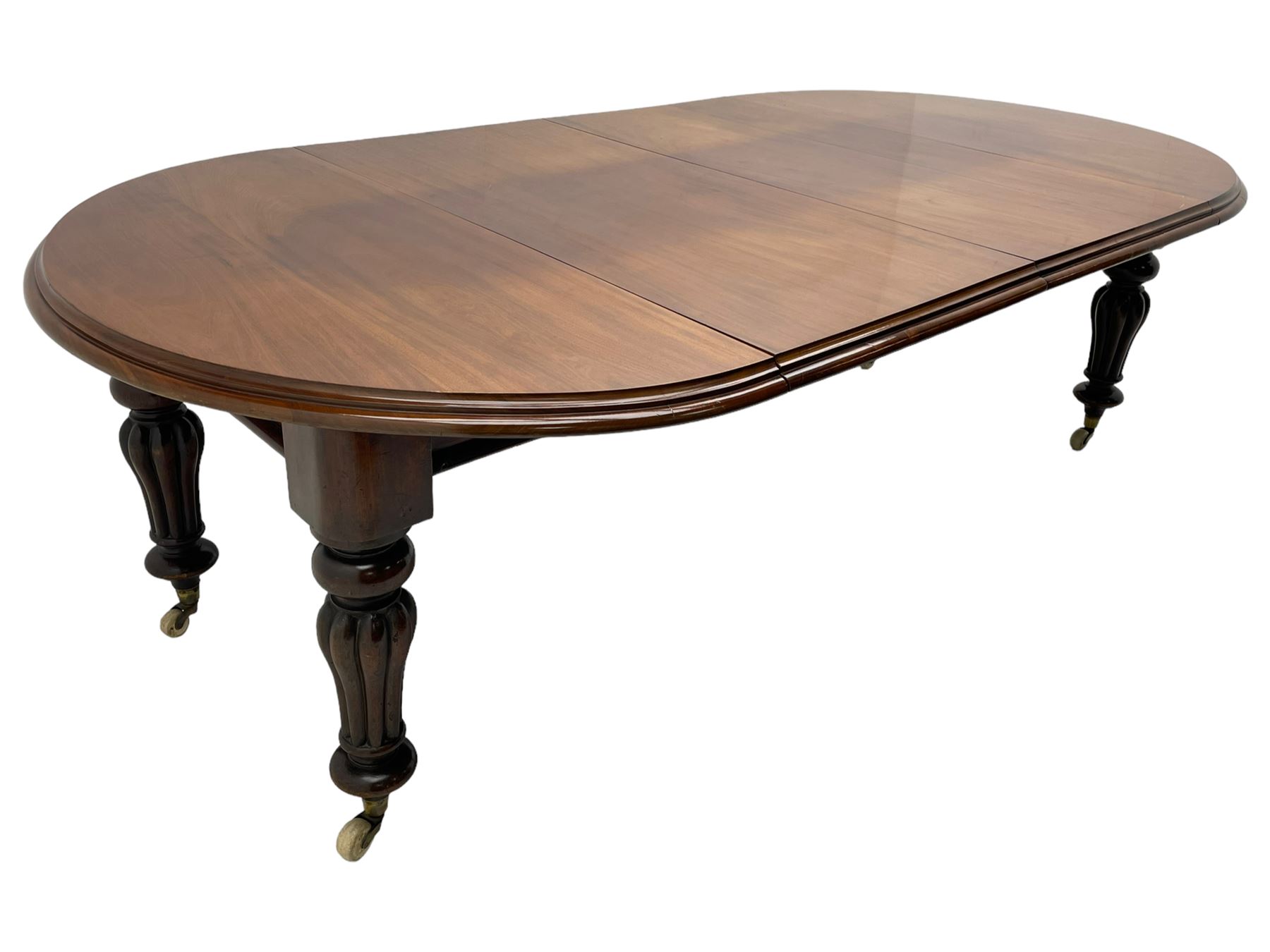 Victorian mahogany extending dining table, circular telescopic extending top with moulded edge, two additional leaves, on turned and lobe carved supports with brass and ceramic castors 