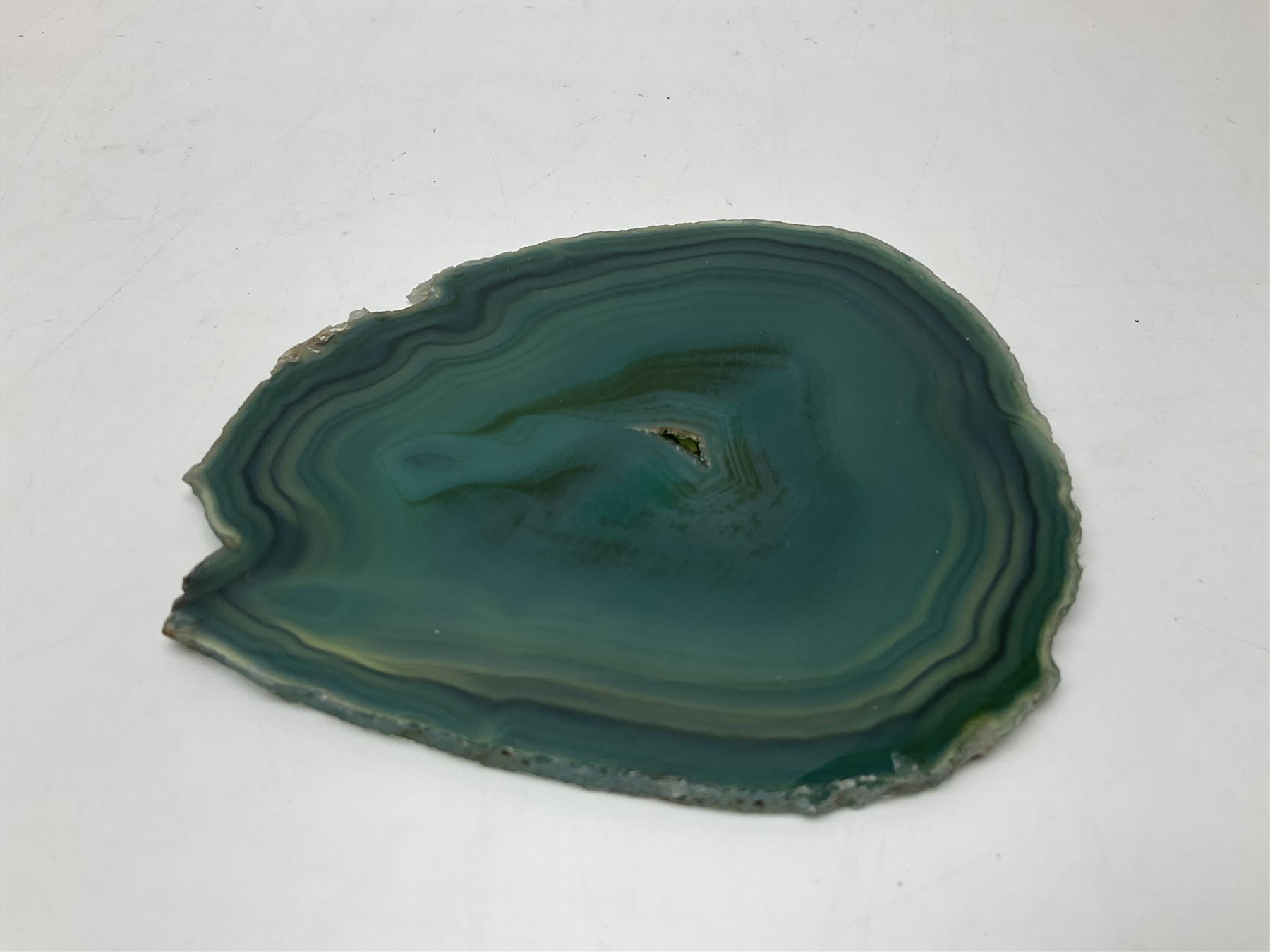 Pair of green agate slices, polished with rough edges, raised upon silvered metal stands, H23cm
