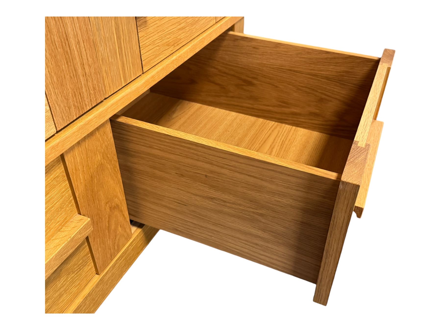 Contemporary light oak triple wardrobe, panelled doors with vertical linear design, left section enclosing hanging rail and single shelf, right section with adjustable shelves, over two drawers, on square stile supports