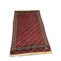 Persian red ground rug, blue and white geometric patterned field, repeating border