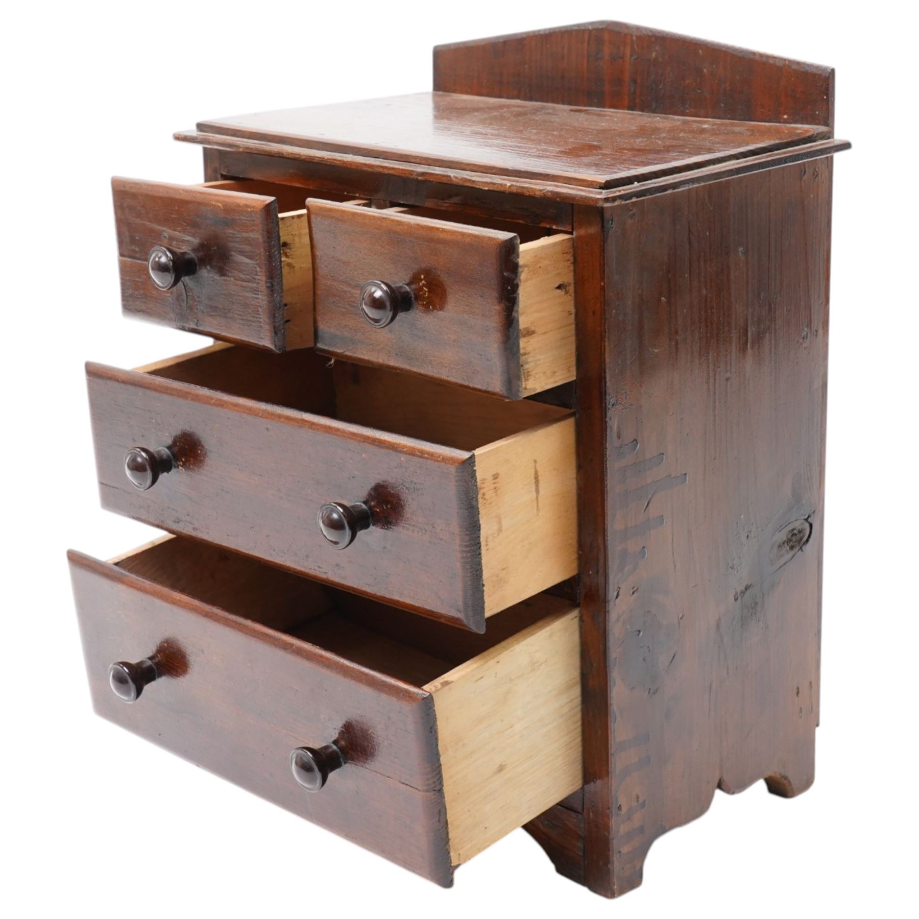 Miniature stained pine chest of two long and two short drawers above a shaped apron W28cm