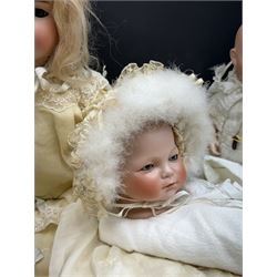 Two German bisque head dolls, to include a Franz Schmidt example with blue glass eyes and an Armand Marseille 590 example with applied hair, together with a Schoenau & Hoffmeister bisque doll's head, pair of doll's hands and a collection of clothing