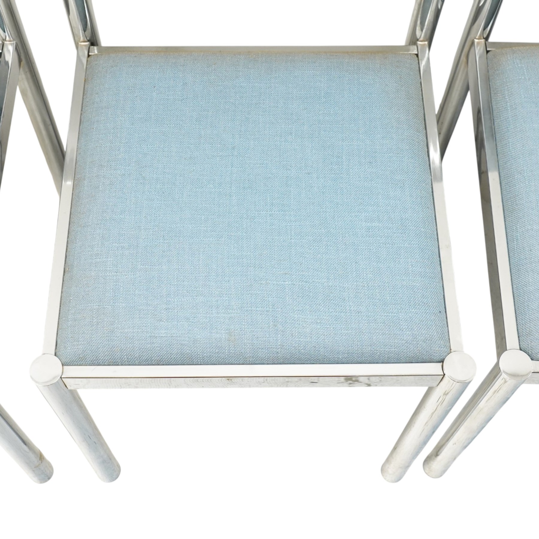 Set of eight 1980s chrome and upholstered dining chairs, curved back bar over padded seats upholstered in blue fabric, on tubular chrome frames