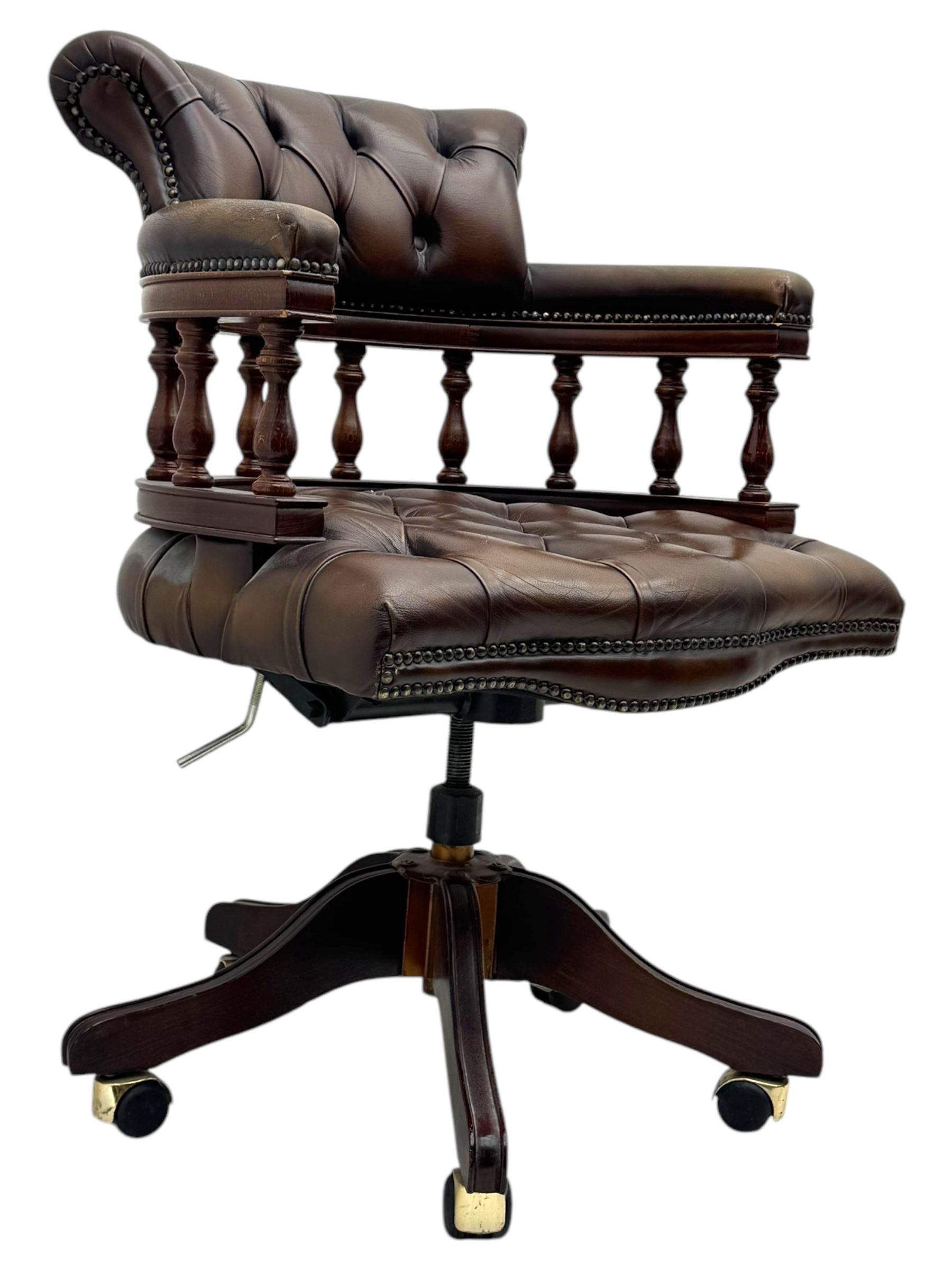 Mahogany framed swivel Captains desk chair, upholstered in brown buttoned leather, turned supports and swivel base on castors