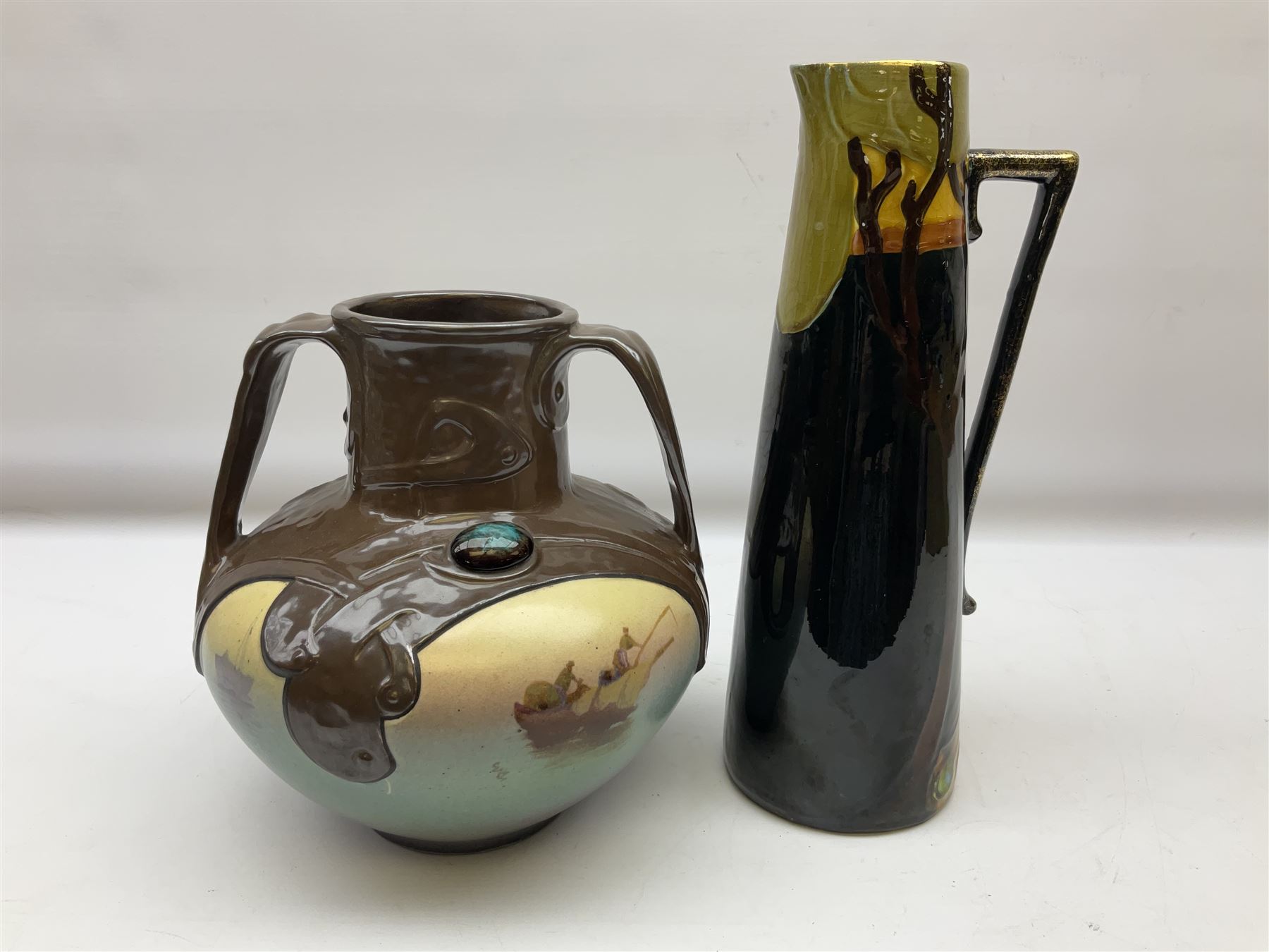 T. Forester Phoenix ware ewer of tapering form decorated with peacock and Bretby twin handled vase decorated with figures fishing in a boat sea scene