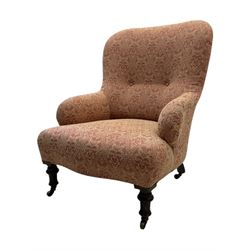 Late Victorian upholstered armchair, with high camel back and deep seat, padded arms and backrest in crimson and cream damask-style fabric, raised on turned ebonised front supports with ceramic castors (H88cm, W65cm, D 60m); and an Edwardian bedroom chair with button upholstered rail back (H72cm, D64cm, W53cm) (2)