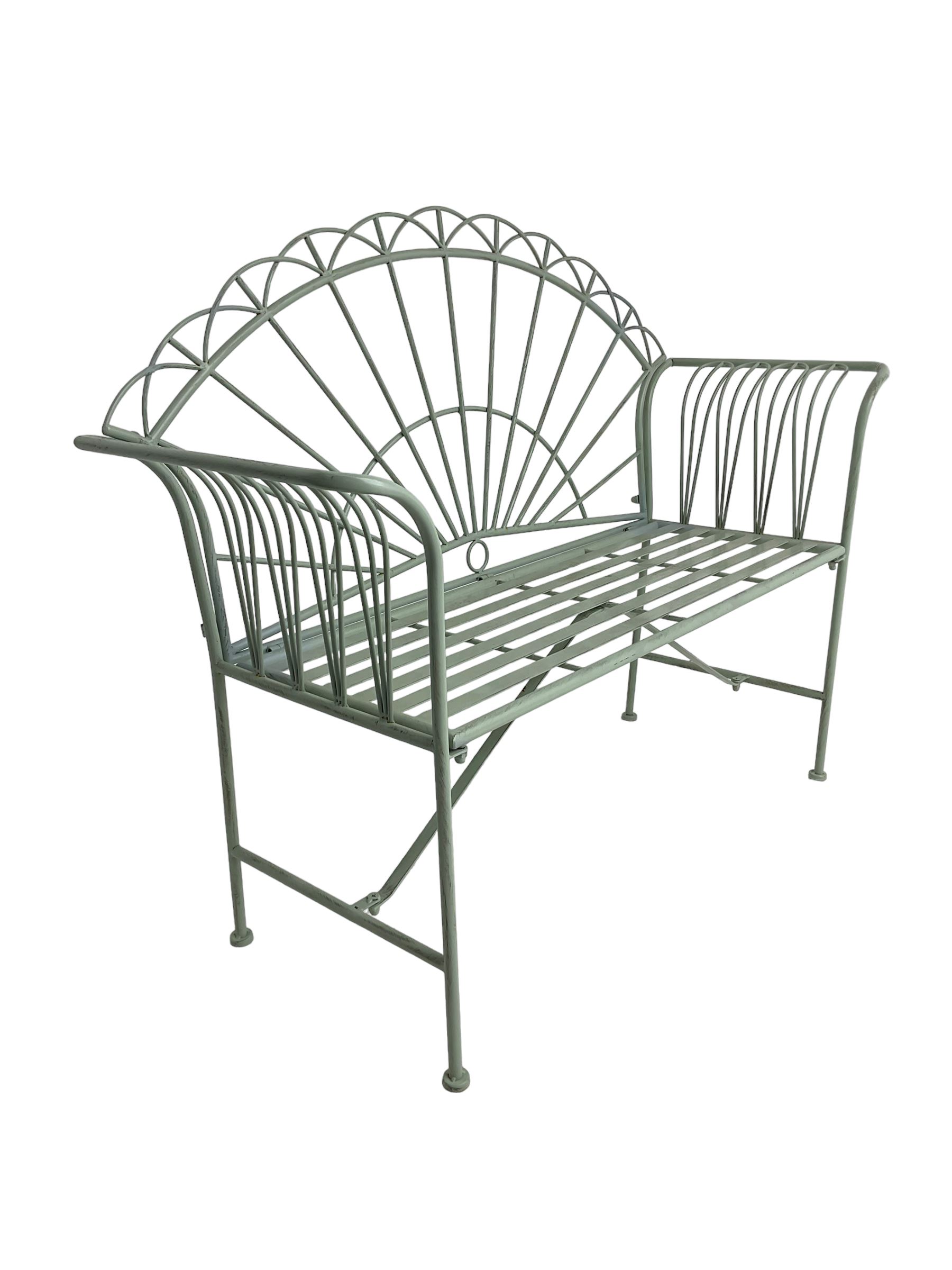 Regency design wrought metal bench, the fan back over out-swept arms, strap seat on supports united by stretchers, in pale teal finish