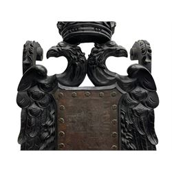 Grand mid-to-late 19th century heavily carved beech framed throne chair, the crown pediment carved with flower heads and cross finial, scroll and acanthus carved upright supports with twin perching griffin back enclosing etched leather work heraldic shield with castle and lion motifs over splayed feathers, flower head carved down sweeping arms with grotesque carved terminals, the seat rails carved with further flower heads on moulded supports with oversized ball and claw carved feet

Provenance: A very similar chair was used in the filming of Stanley Kubrick's 'Eyes Wide Shut' (1999)
