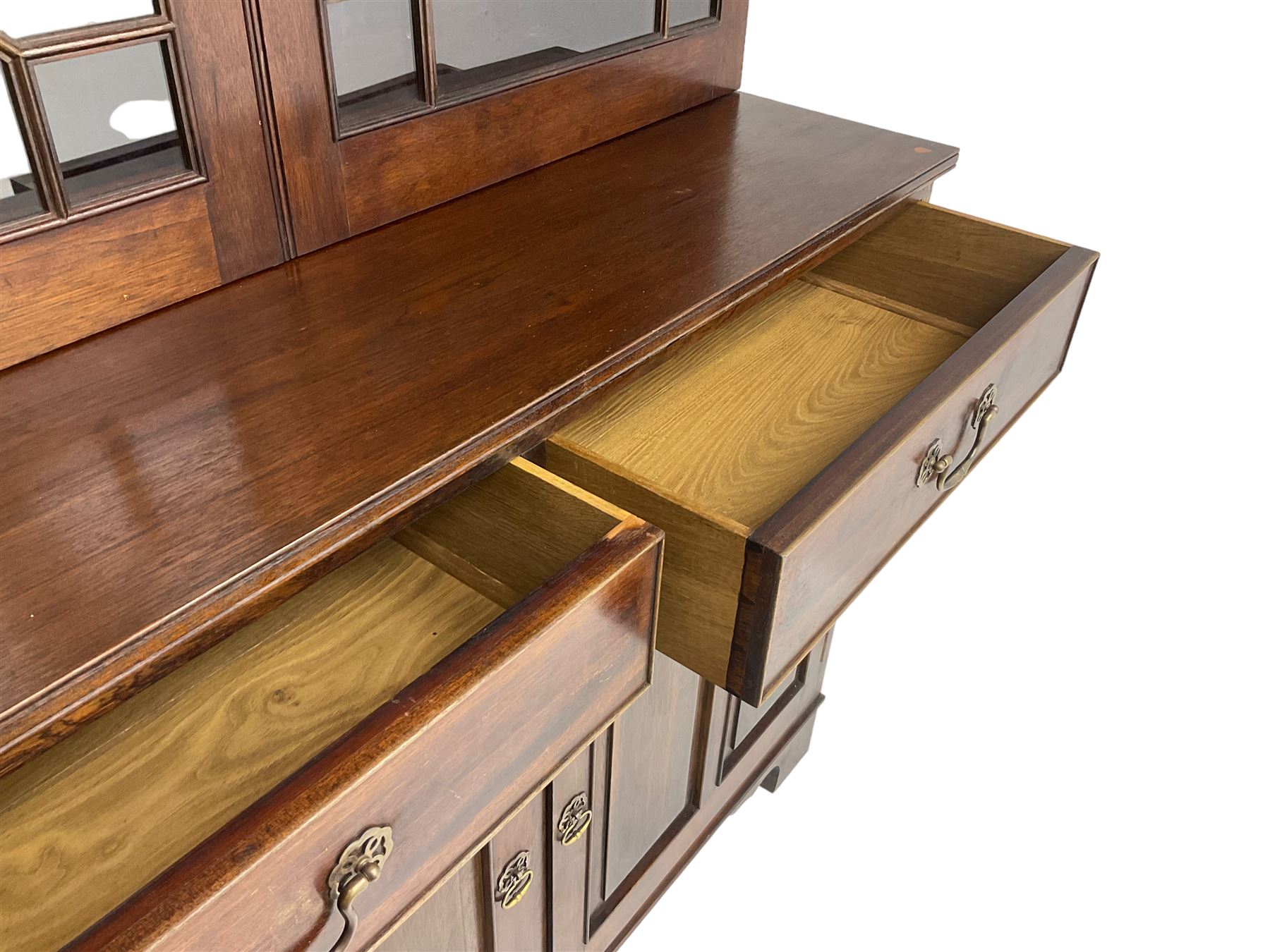 Acorn Industries - Georgian design mahogany bookcase on cupboard, fitted with two astragal glazed doors enclosing three glass shelves, base with two cock-beaded drawers over two panelled cupboards, inlaid with acorn signature, by Alan Grainger, Brandsby