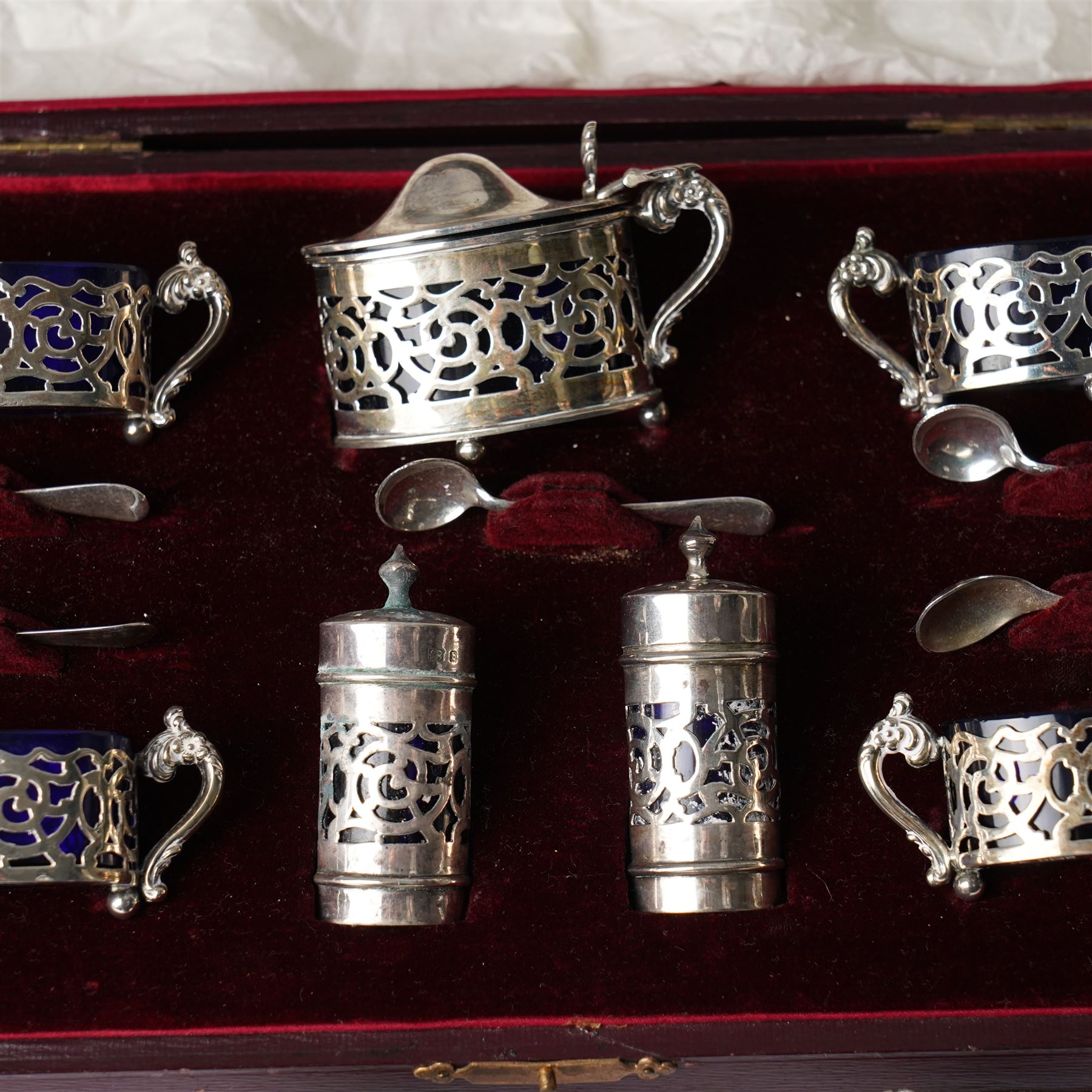 Set of four Edwardian pierced silver salts and matching mustard pot, all with blue glass liners Birmingham 1901 Maker William Devenport, cased, together with a pair of similar pepperettes 1900 Maker Walker & Hall, Georg Jensen sterling silver cauldron shape salt on ball feet, plated coaster, plated salt and silver topped jar