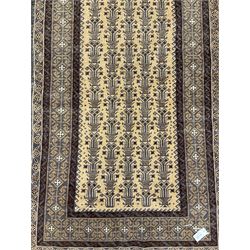 Persian pale ground rug, the field decorated with repeating plant motifs, the border with geometric design 