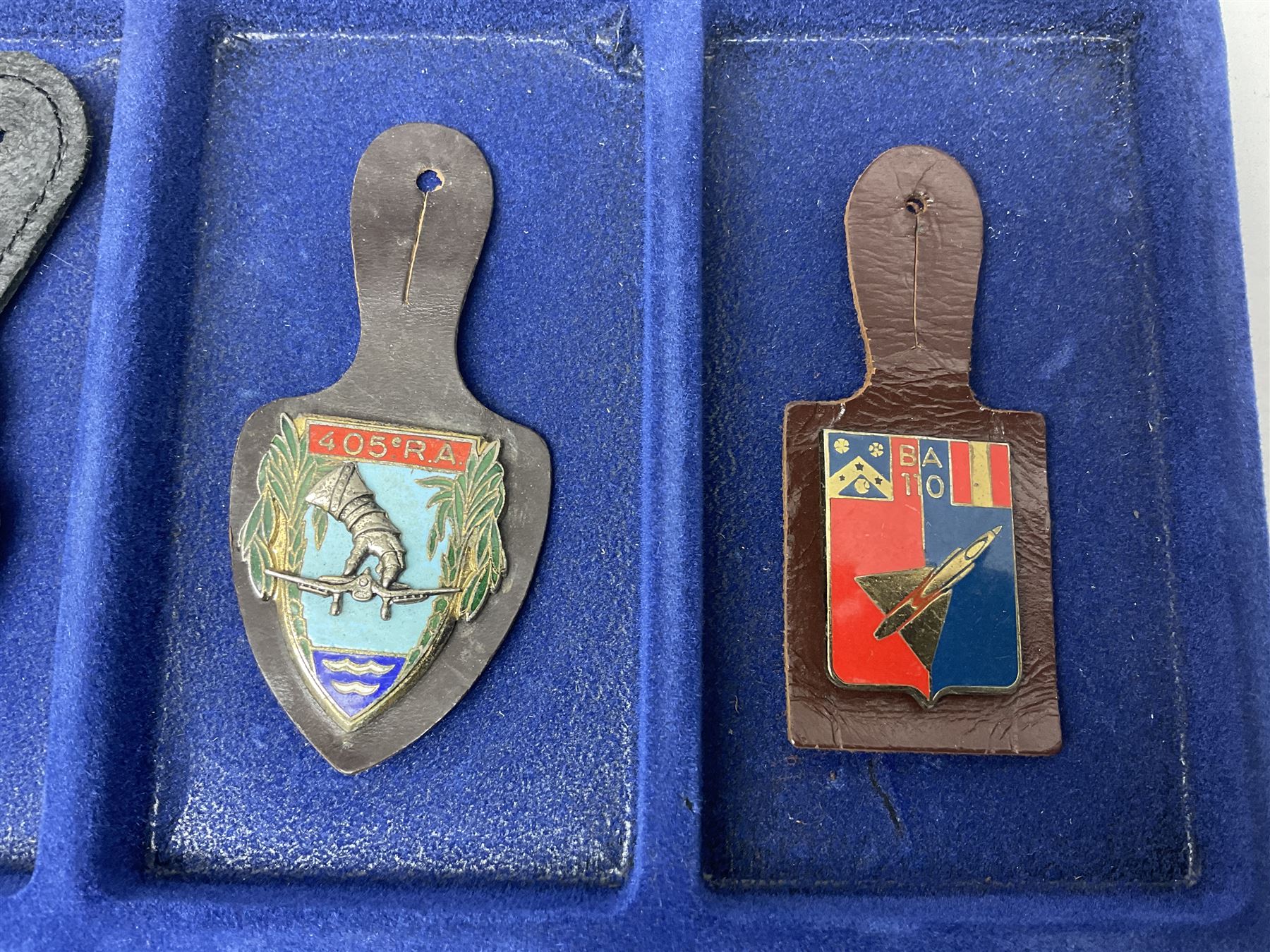 Twelve French military metal badges mounted on leather fobs including Legion, Artillery, Parachutist, Air Force, Infantry etc