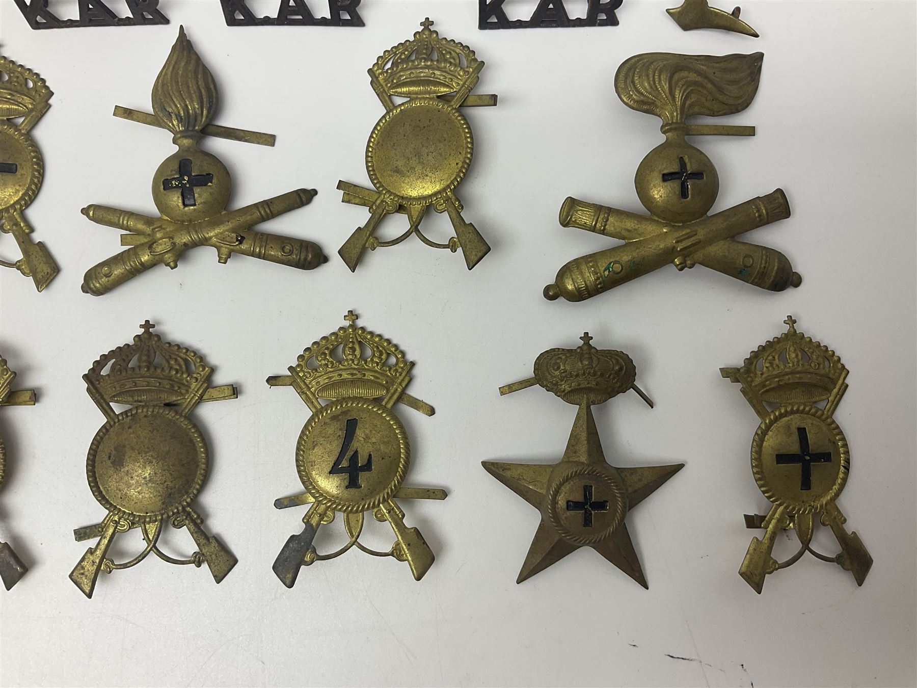 Over thirty British and Continental military metal badges; together with quantity of shoulder titles, collar dogs, rank pips, uniform buttons etc
