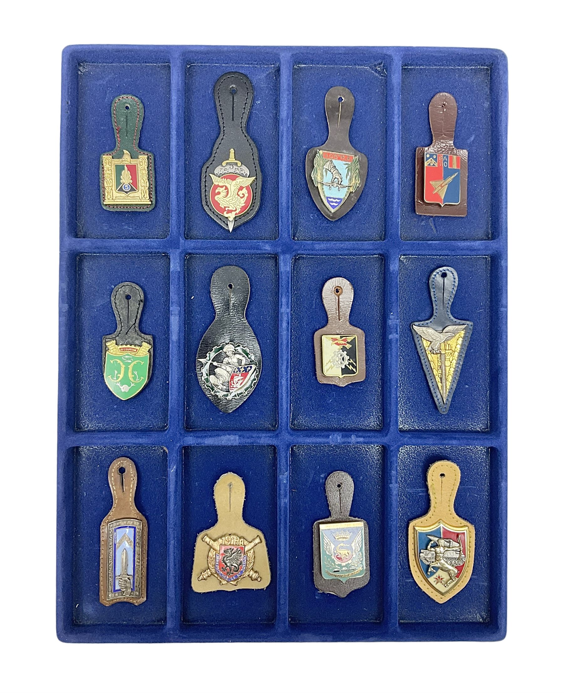 Twelve French military metal badges mounted on leather fobs including Legion, Artillery, Parachutist, Air Force, Infantry etc