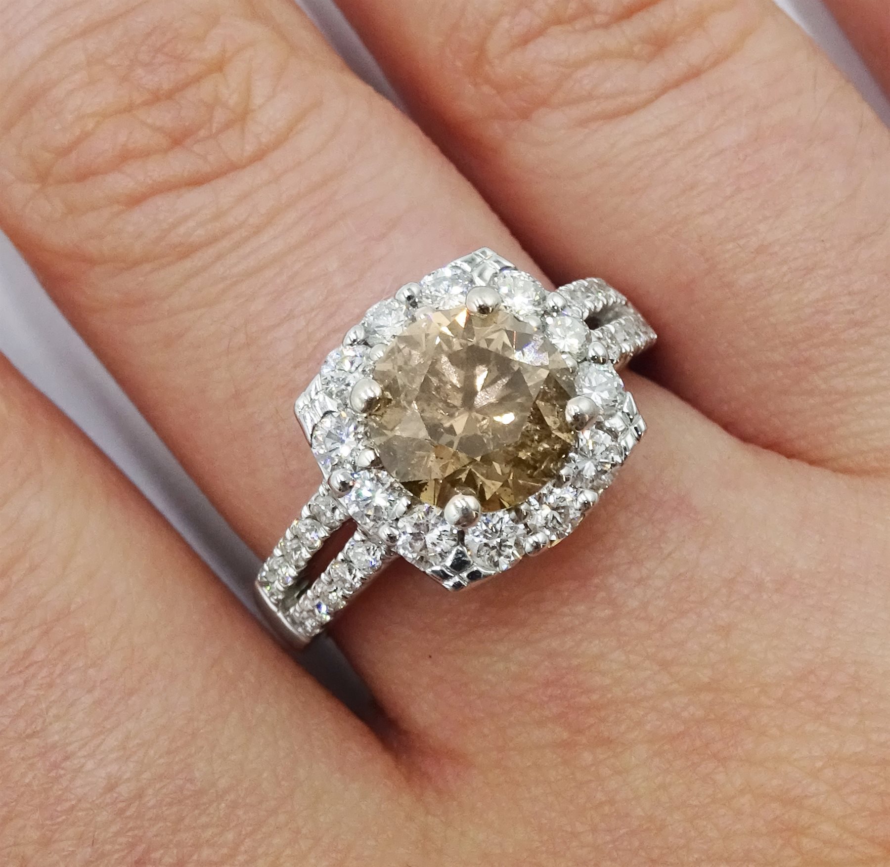 18ct white gold round brilliant cut fancy light brown diamond ring, with halo diamond surround and diamond set shoulders, stamped 750 18K, central diamond 2.00 carat, total white diamond weight 0.90ct