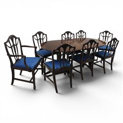 Set of eight George III style mahogany dining chairs, comprising two carvers and six singles, each with shaped top rail above pierced splay carved with feathers, with drop in stuffover seats upholstered in blue striped fabric, raised upon square tapering legs joined by stretchers, together with a mahogany twin pedestal dining table, the oval top with central leaf raised upon turned columns and splayed reeded legs terminating in lion paw feet and brass castors, 