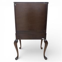 20th century Queen Anne style mahogany cocktail cabinet, moulded cornice above a pair of fielded panel doors with decorative strap hinges and central escutcheon, opening to a mirrored interior fitted with tiered shelves with brass gallery rails, pull-out glass inset mixing slide above three short drawers, shaped apron on cabriole supports with carved shell knees terminating in pad feet