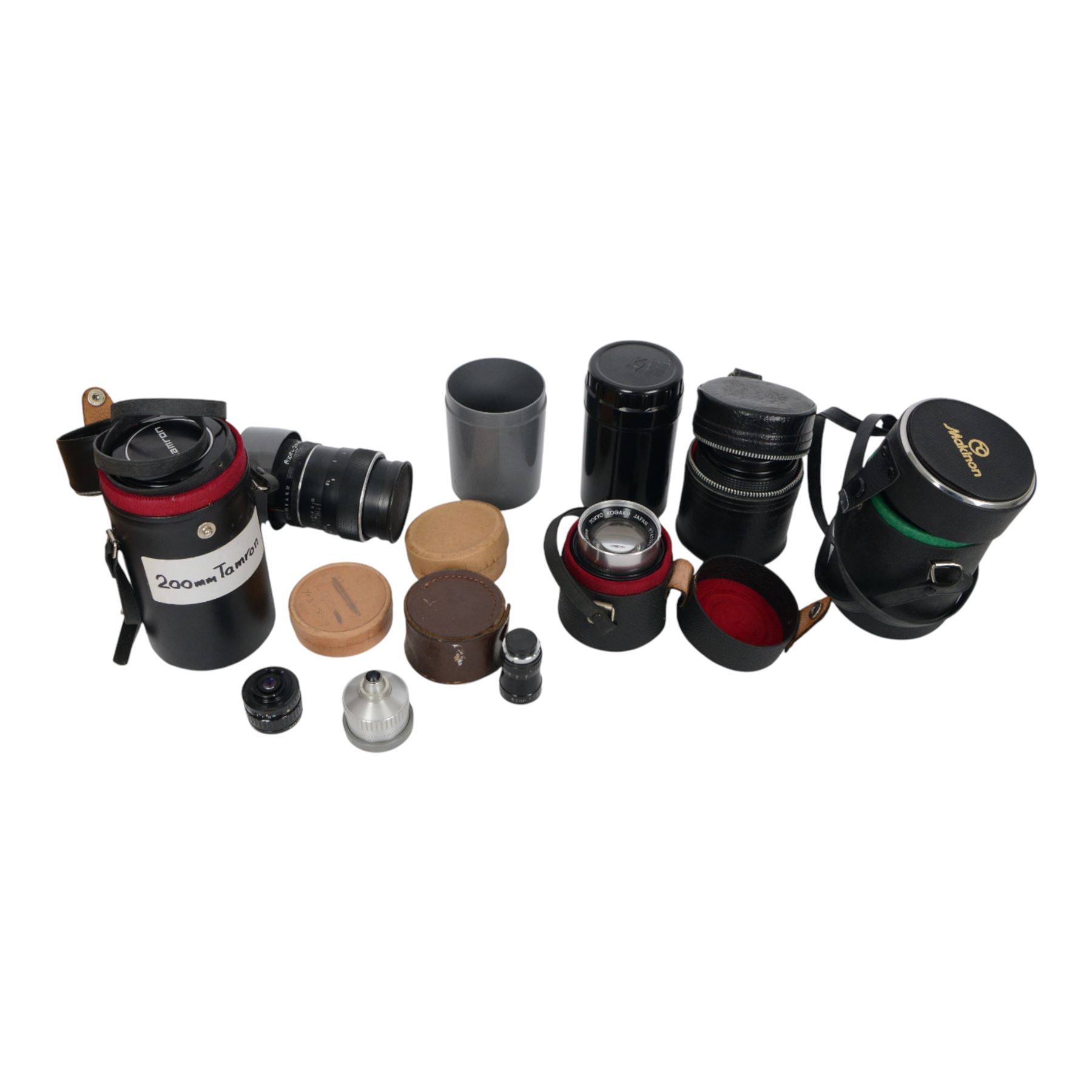 Collection of camera lenses, including Tamron 1:3.5 f=200mm, Makinon MC Zoom 1:3-4.5 35mm-105mm, Topcor 1:4 f=100mm, Acall 6.5mm f:1.4 wide angle lens, etc