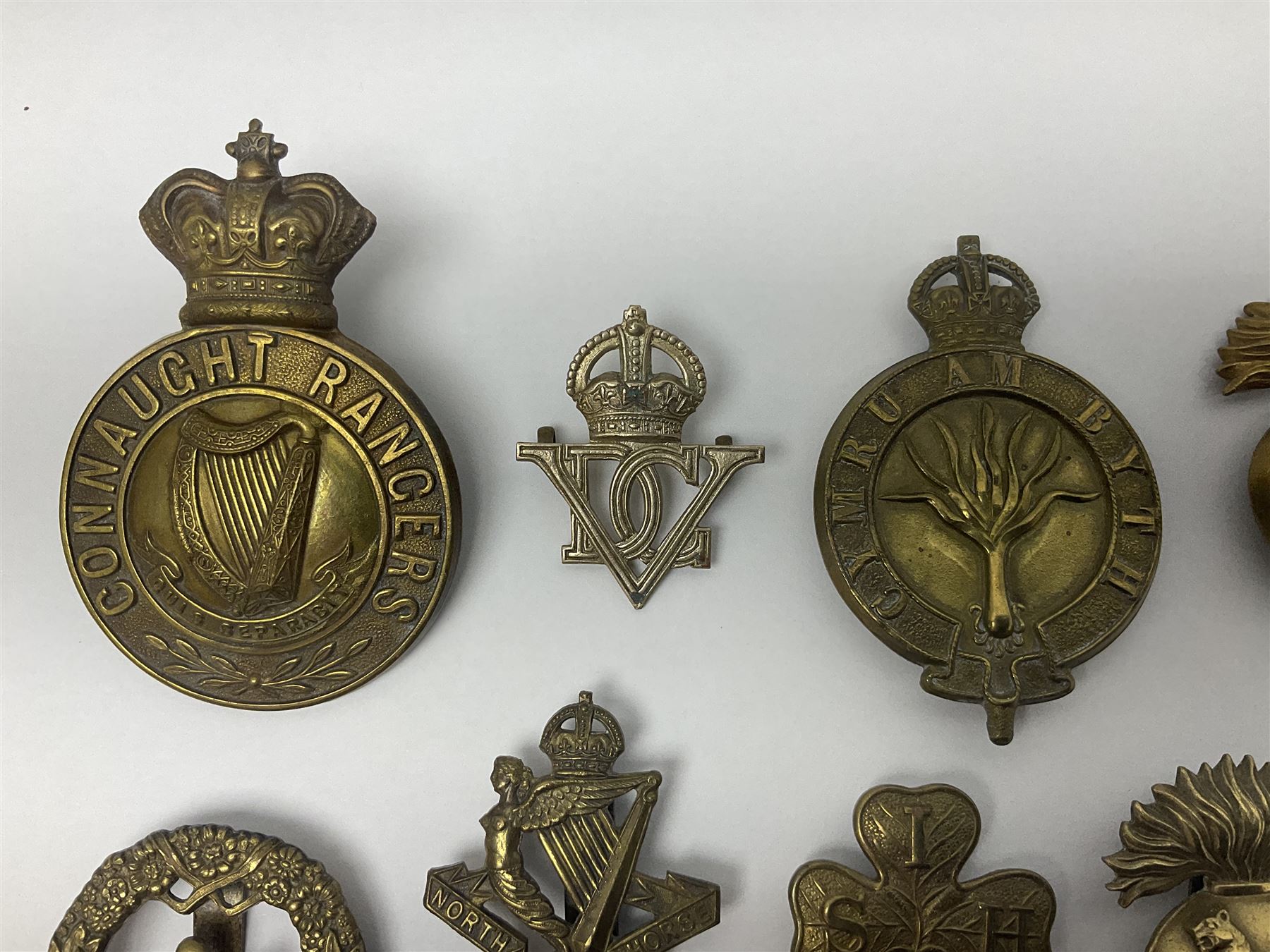 Fourteen cap badges of Irish interest including Royal Dublin Fusiliers inscribed to the slider 'From A. O'Connor 2nd Batt. Dec.2nd 1915', Connaught Rangers, South irish Horse Yeomanry, Inniskilling Fusiliers, Royal Irish Regiment etc; and seven Welsh badges including South Wales Borderers, Welsh Guards, 3rd Bn. Monmouthshire Regt. etc (21)