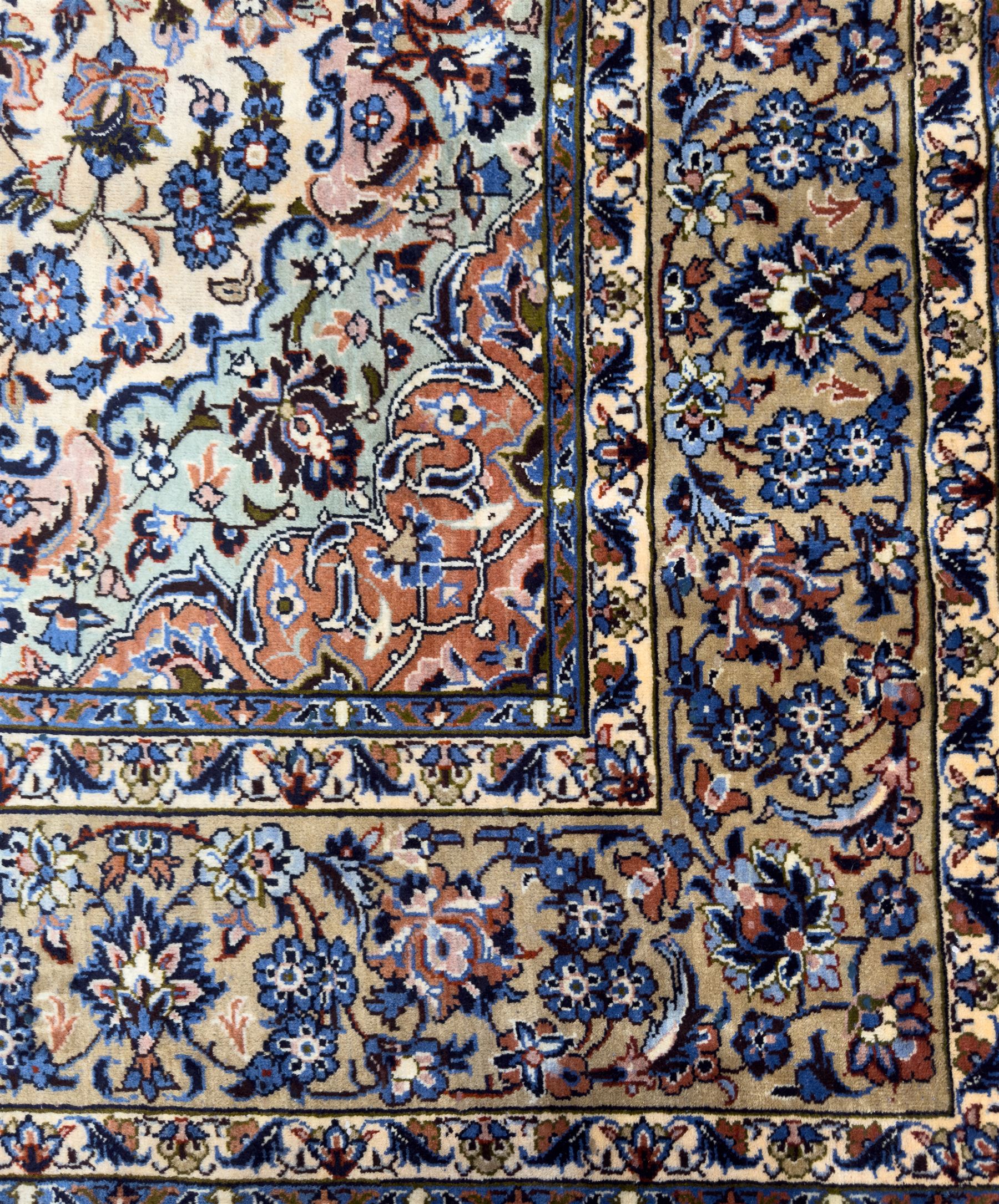 Central Persian Najafabad hand-knotted carpet, the ivory field with a central floral medallion radiating palmettes and arabesques in tones of blue, lilac and tan, enclosed by a wide navy border of scrolling vine and rosette motifs, with red spandrels and multiple guard stripes