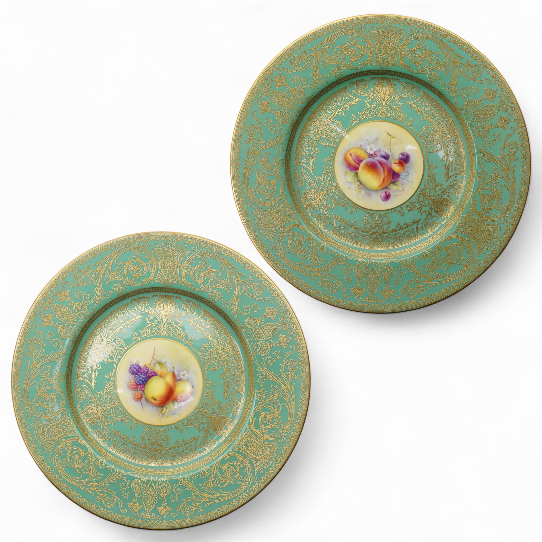 Pair of Royal Worcester cabinet plates painted with central panel of fruit by Peter Platt signed 'P Platt' within a green and gilt surround D27cm