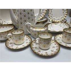 Modern Spode coffee and dinner wares for six place settings, decorated in the Fleur De Lys Gold pattern, comprising dinner plates, dishes, side plates, one handled fan shaped serving dish, coffee pot, coffee cans, saucers, open sucrier and cream jug, with red and black printed marks beneath 