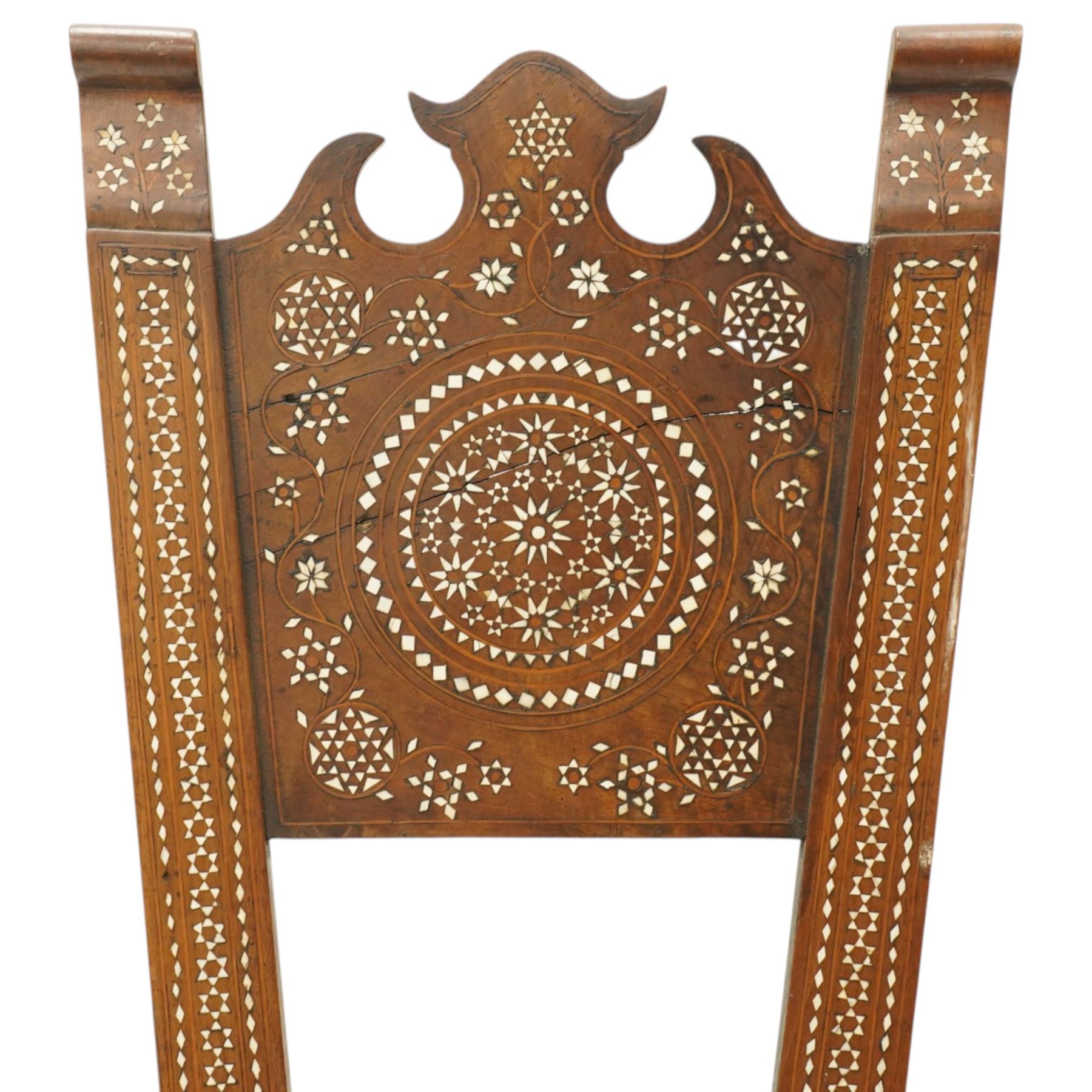 19th century Syrian olive wood and ivory inlaid chair, the shaped back and cresting above a panel centred by a circular starburst roundel within geometric and foliate marquetry and stringing, the tapering uprights and frame extensively inlaid with repeating ivory motifs, the octagonal seat similarly decorated, raised on splayed legs united by H-stretcher with further inlaid ornament
