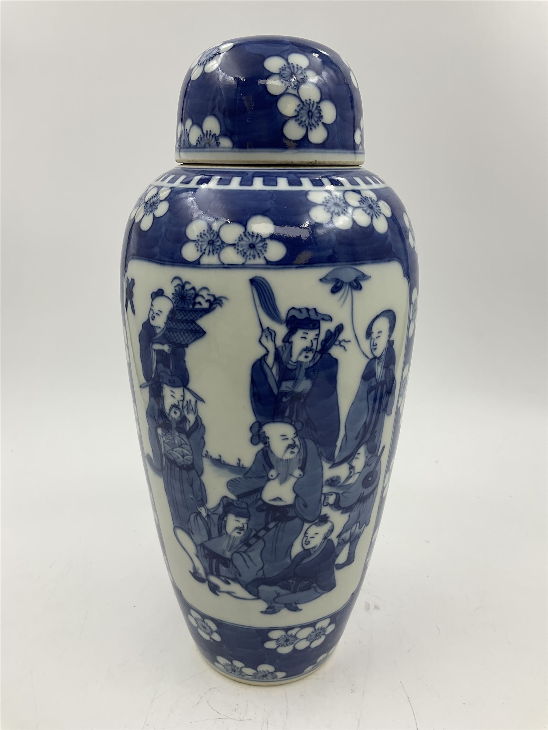 Late 19th century Chinese blue and white jar and cover, of slender ovoid form with domed cover, decorated with two reserves containing figures, against a prunus blossom ground, with Kangxi type mark beneath, H27.5cm