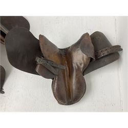 Collection of nine saddles, mainly havana leather to include a racing saddle and a Goodwin saddle, some with stirrups and leathers 