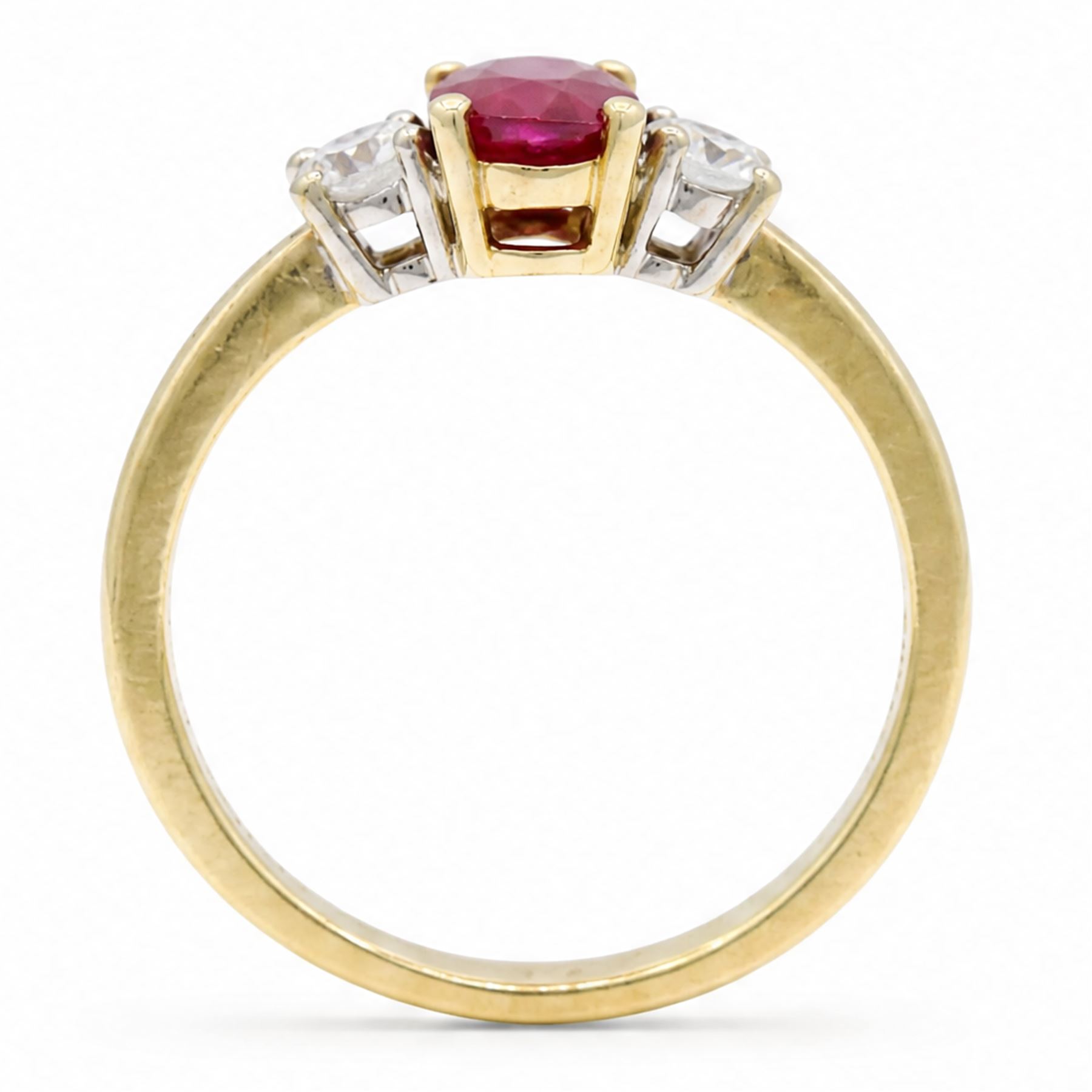 18ct gold ruby and diamond three stone ring, single oval cut ruby of 1.06 carat, with a round brilliant cut diamond set either side, hallmarked, total diamond weight 0.31 carat