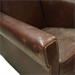 Early to mid 20th century pair of wingback armchairs, upholstered throughout in chocolate brown leather, the backs with deep wings, square padded arms with piped seams, loose seat cushions over solid bases
