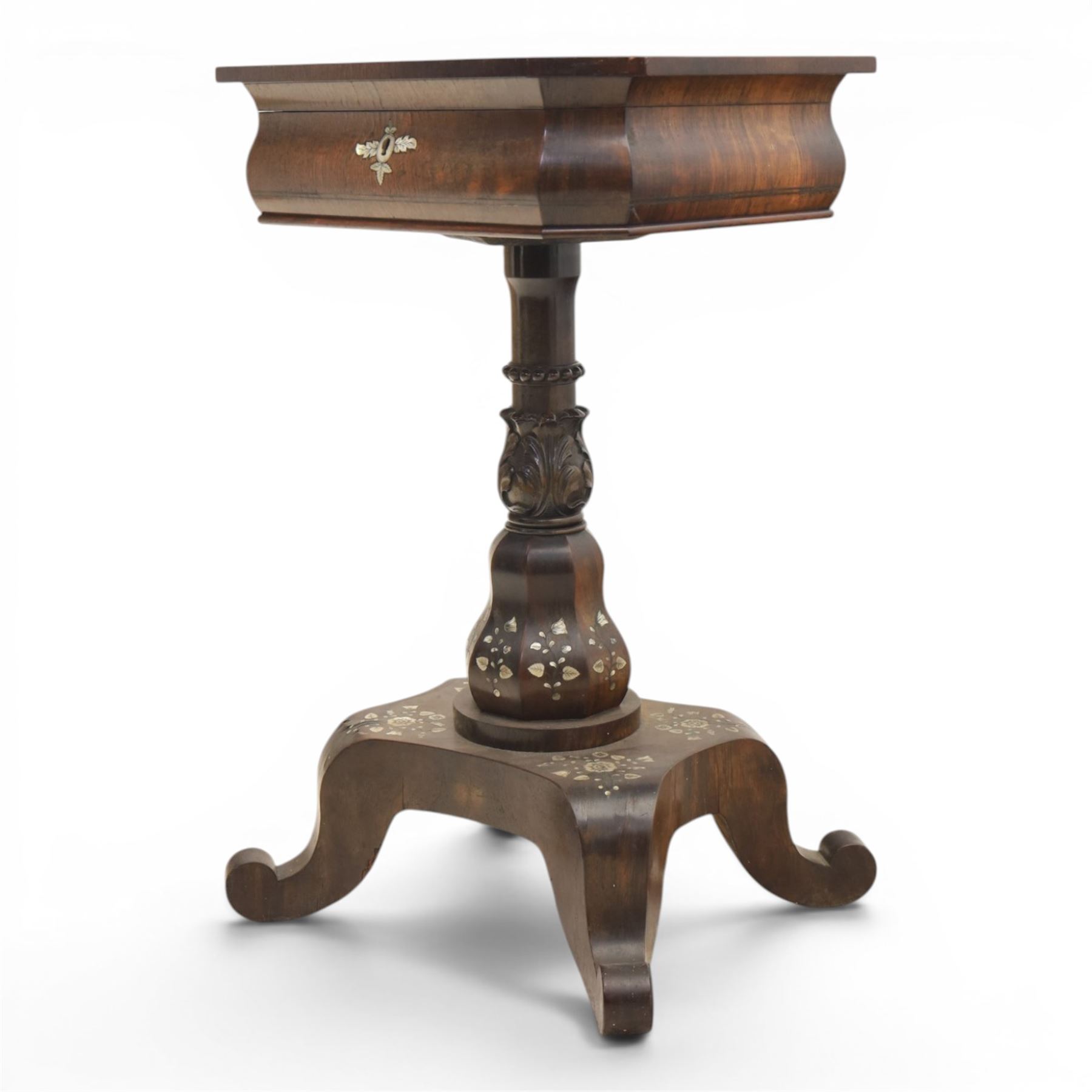 Victorian mahogany and mother-of-pearl inlaid work table, the octagonal hinged top enclosing a mirror and fitted compartmented interior, raised on a carved pedestal and quatriform platform base with scrolled feet