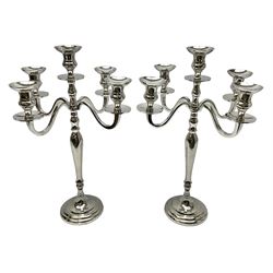 Pair of four branch candelabras, urn-shaped nozzles raised upon scroll branches supported from tapering central stem, with a stepped circular base, H46cm