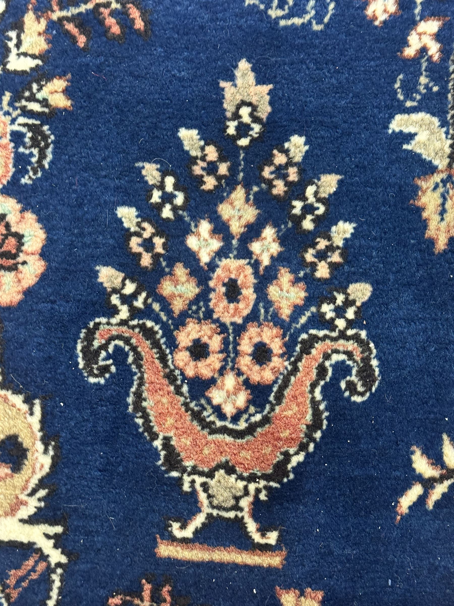 Persian Herati design indigo and red ground carpet, decorated with floral motifs, arched border