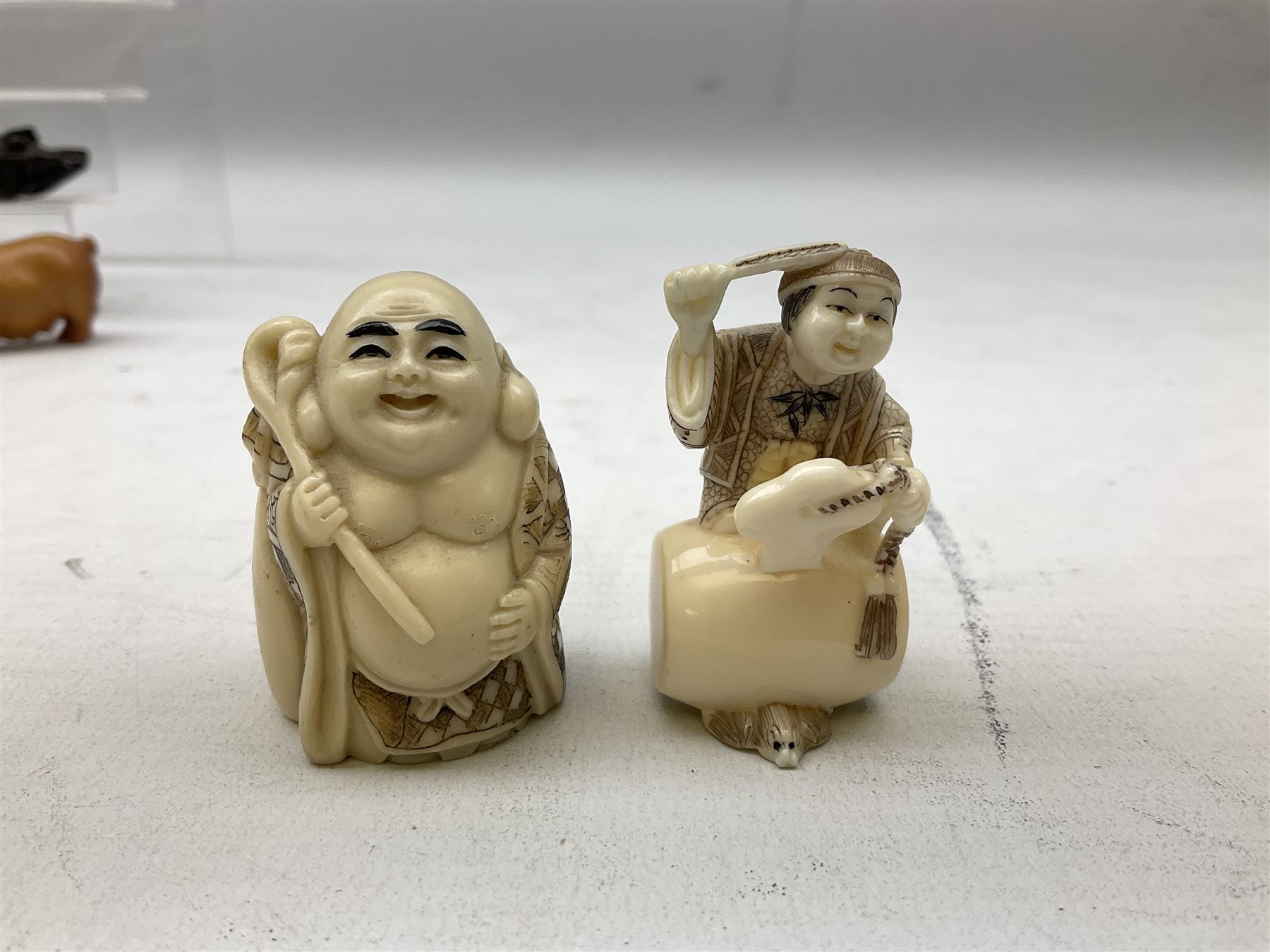 Group of ten Japanese netsukes, comprising eight carved wooden examples, and two ivorine examples, of various form, examples modelled as pigs, owl, mouse with tortoise upon its back, birds, rabbit, etc. 