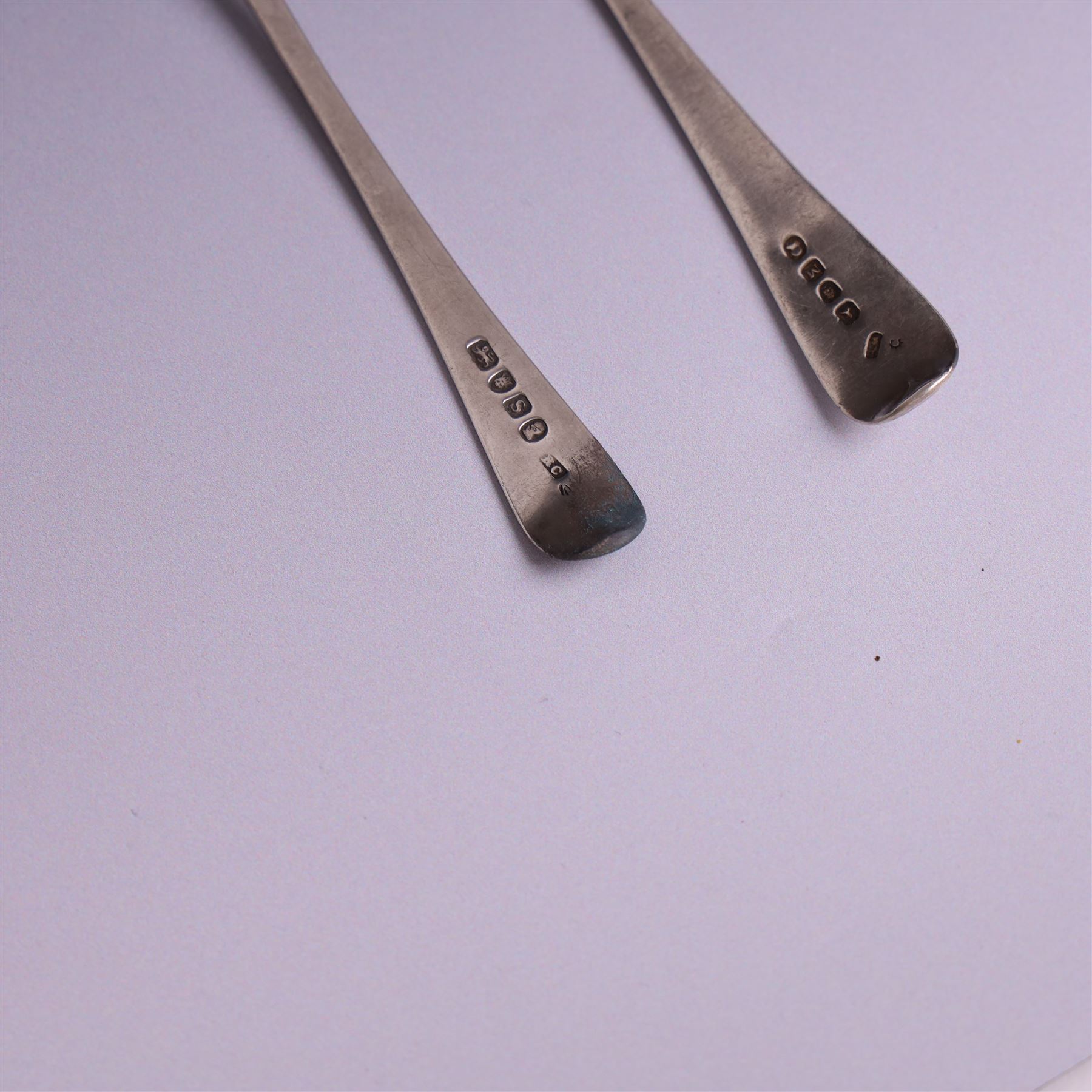 Two George III Old English pattern silver spoons, each engraved with arm and hammer crest to terminal, both hallmarked