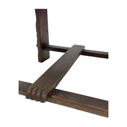 Pair of Arts and Crafts oak armchairs each with shaped backrest centred by polychrome painted crest, rush seat over straight square legs united by shaped central stretcher