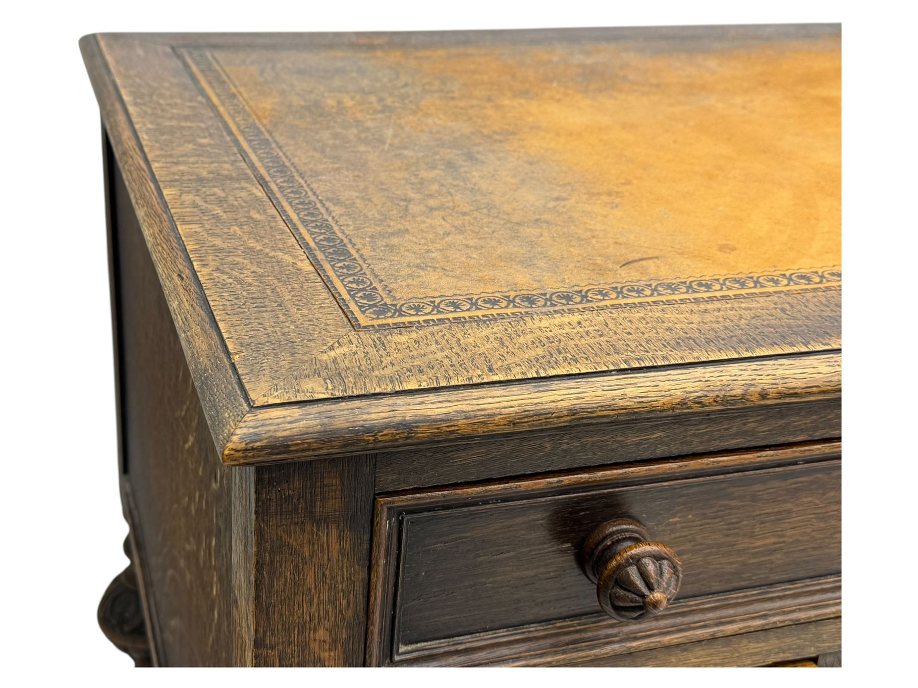 Early 20th century Jacobean design oak desk, with rectangular top inset with worn tooled leather, two frieze drawers over pedestals each fitted with a pair of panelled drawers, turned handles, on carved and fluted tapering legs united by stretchers 